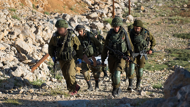 Ein syrischer Verletzter wird zu einem israelischen Feldlazarett getragen.